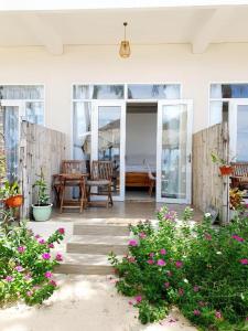 a patio with a table and chairs and flowers at Ocean Breeze Bungalow in Sông Cầu +31 photos