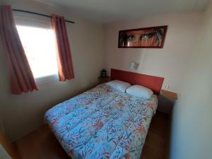a bedroom with a bed with a red headboard and a window at Le doux refuge de l'Yères in Touffreville-sur-Eu