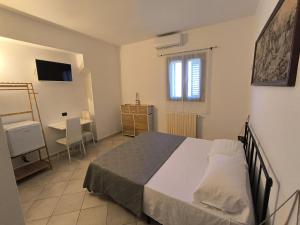 a bedroom with a bed and a table and a window at Residenza Borgo Francescano in Gioia del Colle