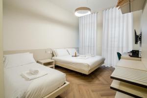 a hotel room with two beds and a desk at Italianflat - Duomo Atmosphere Two in Milan