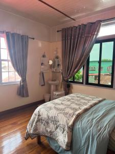 a bedroom with a bed and a window at staylikehome guesthouse in Nieuw Nickerie