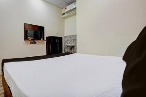 a bedroom with a white bed and a tv at hotel orange palace in Surat