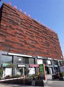 a large brick building with at hotel orange palace in Surat