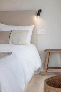 ein Schlafzimmer mit einem weißen Bett und einem Holztisch in der Unterkunft Casa Otea in Avila
