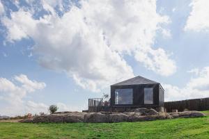 ein kleines schwarzes Haus auf einem Steinhaufen in der Unterkunft Casa Otea in Avila