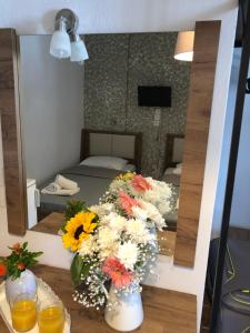 a reflection of a room with flowers in a mirror at Armonia Guest House in Skiathos +18 photos