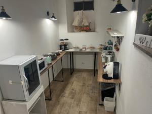 a room with a kitchen with a table and a microwave at B&b Red House in Garlate +33 photos