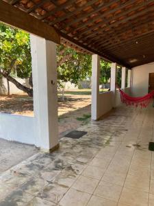 an empty patio with a red hammock under a building at Aconchego&Lazer in Piaçabuçu