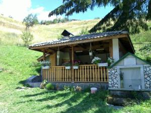 a small house with a wooden deck in a field at Къща Ники in Stoykite