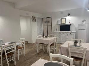 a dining room with tables and chairs and a kitchen at B&b Red House in Garlate
