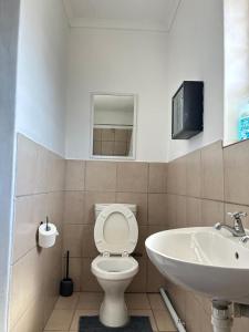 a bathroom with a white toilet and a sink at Shine house in Somerset West