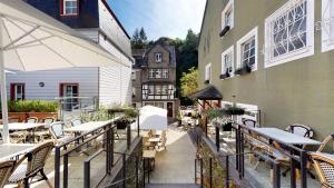 an outdoor patio with tables and chairs and a building at Hotel Alt Montjoie in Monschau