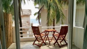 two chairs and a table on a balcony at Ocean Breeze Bungalow in Sông Cầu