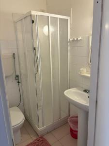 a bathroom with a shower and a toilet and a sink at Hotel & Trattoria Le Caravelle in Lavagna