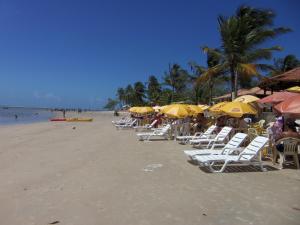 un gruppo di sedie e ombrelloni in spiaggia di Pousada Aldeia do Sossego a Santa Cruz Cabrália