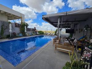 a large swimming pool with chairs and an umbrella at צדפת המדבר in Giv'ot Bar