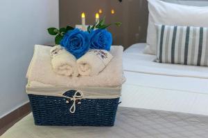 Ein Korb mit Handtüchern und Rosen auf einem Bett in der Unterkunft Blue line in Kalathos