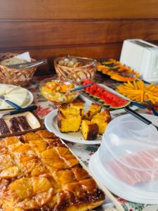 a table topped with plates of food and desserts at Refúgio Allamanda in Visconde De Maua