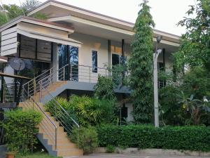 a house with stairs and plants in front of it at โรงแรมเพ็ญวิวรีสอร์ท Phenview resort in Amphoe Phen