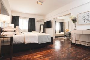 ein Hotelzimmer mit Bett und Fernseher in der Unterkunft Hotel Tolosa in Puerto Madryn