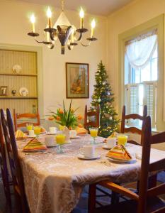 a dining room with a table with a christmas tree at Pryor House B&B in Bath