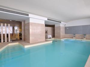 a large blue swimming pool in a building at Sangallo Palace in Perugia