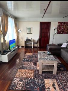 a living room with a couch and a table at staylikehome guesthouse in Nieuw Nickerie