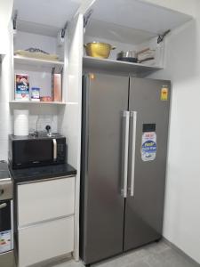 a kitchen with a refrigerator and a microwave at Escape to Eden Heights in Tokuse