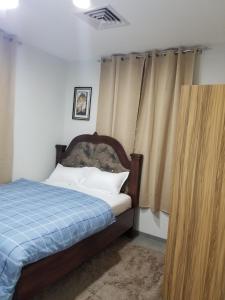 a bedroom with a bed with a blue blanket at Escape to Eden Heights in Tokuse