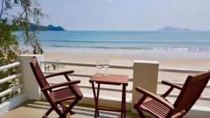 two chairs and a table on a balcony with the beach at Ocean Breeze Bungalow in Sông Cầu