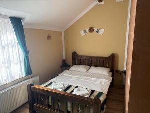 a bedroom with a bed with a wooden frame and a window at HANUL TENTEA in Săcel