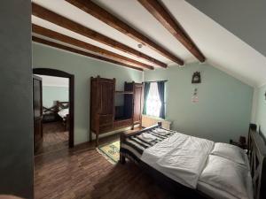 a bedroom with a bed in a room with wooden ceilings at HANUL TENTEA in Săcel