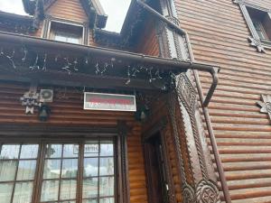 a sign on the side of a wooden building at HANUL TENTEA in Săcel