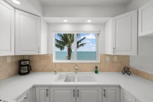 a kitchen with a sink and a window with a palm tree at Island Beach Club #360D in Sanibel +37 photos