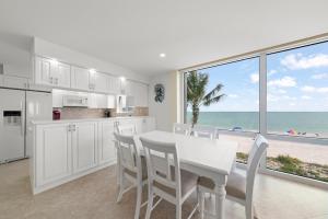 a white kitchen with a table and chairs and the ocean at Island Beach Club #360D in Sanibel
