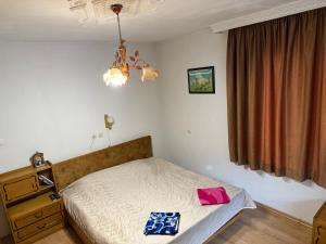a small bedroom with a bed and a window at Къща Ники in Stoykite