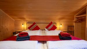a bedroom with a large bed with red and white pillows at Naturfreunde Hostel Grindelwald in Grindelwald