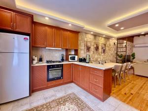 a kitchen with wooden cabinets and a white refrigerator at Attalos Villa in Antalya