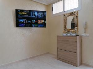 a room with a dresser and a tv on the wall at Résidences nour nador in Nador