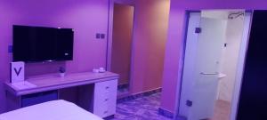 a purple bathroom with a sink and a shower at Transvent Hotel And Suites in Abeokuta