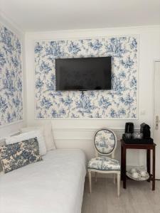a room with a bed and a tv and a chair at Le Molineuf in Orchaise