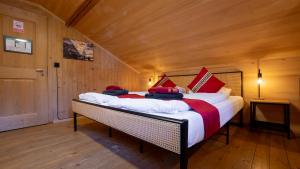 a bedroom with a large bed in a wooden room at Naturfreunde Hostel Grindelwald in Grindelwald