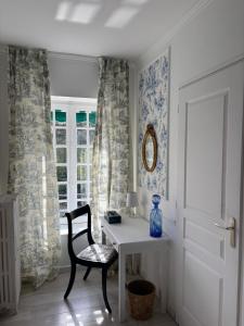 a room with a table and a chair and a window at Le Molineuf in Orchaise
