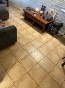 a living room with a table and a tiled floor at Pearlers Lodge in Broome