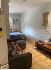a room with a bed and a couch and a table at Pearlers Lodge in Broome +7 photos