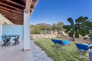 a patio with a table and chairs and a wall at La Casa Azzurra in Tertenìa