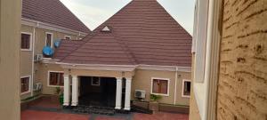 a building with a large roof on a courtyard at Transvent Hotel And Suites in Abeokuta