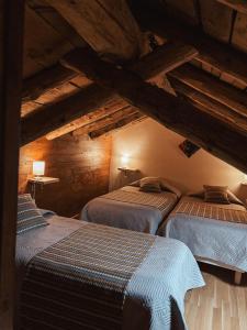 three beds in a room with wooden ceilings at Le Mirasol Appart-hôtel in Enveitg