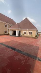 a house with a red brick driveway in front of it at Transvent Hotel And Suites in Abeokuta