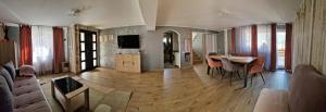 a living room with a table and a dining room at Casa Anitta in Buşteni